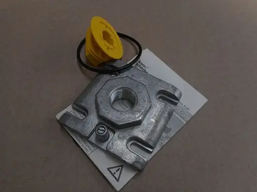 Metallflansch mit einer runden Öffnung und einem gelben Deckel, platziert auf einem weißen Blatt mit technischen Informationen. Produkt gehört zur Marke Remeha.